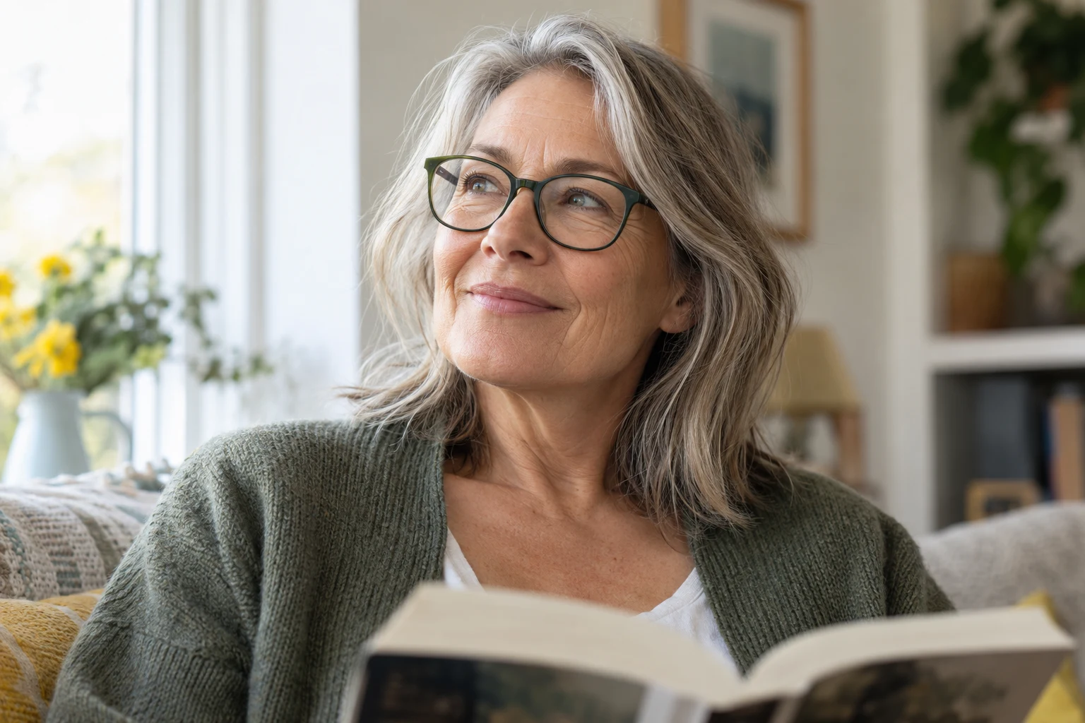 Illustrative image of a woman wearing glasses while reading by a window